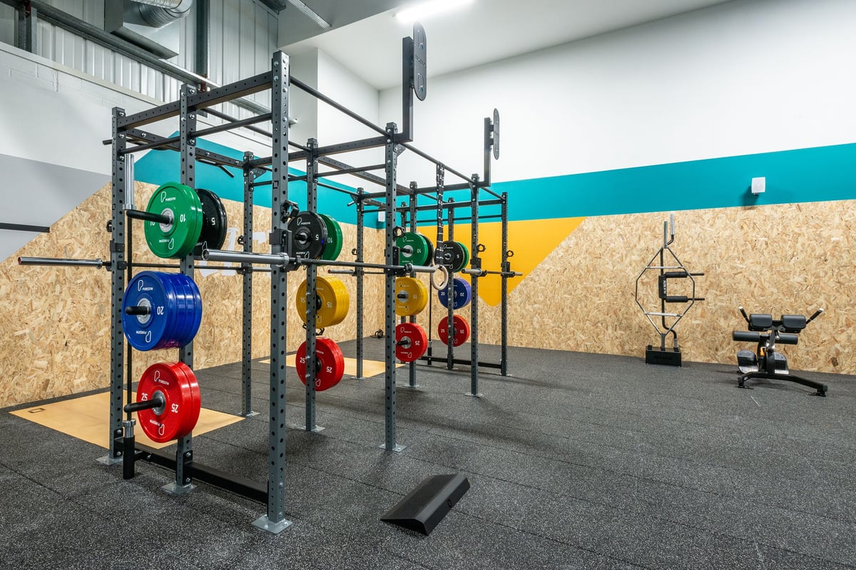 PureGym Oswestry: Power rack, weight plates in multiple colours, rubberized flooring, bench.