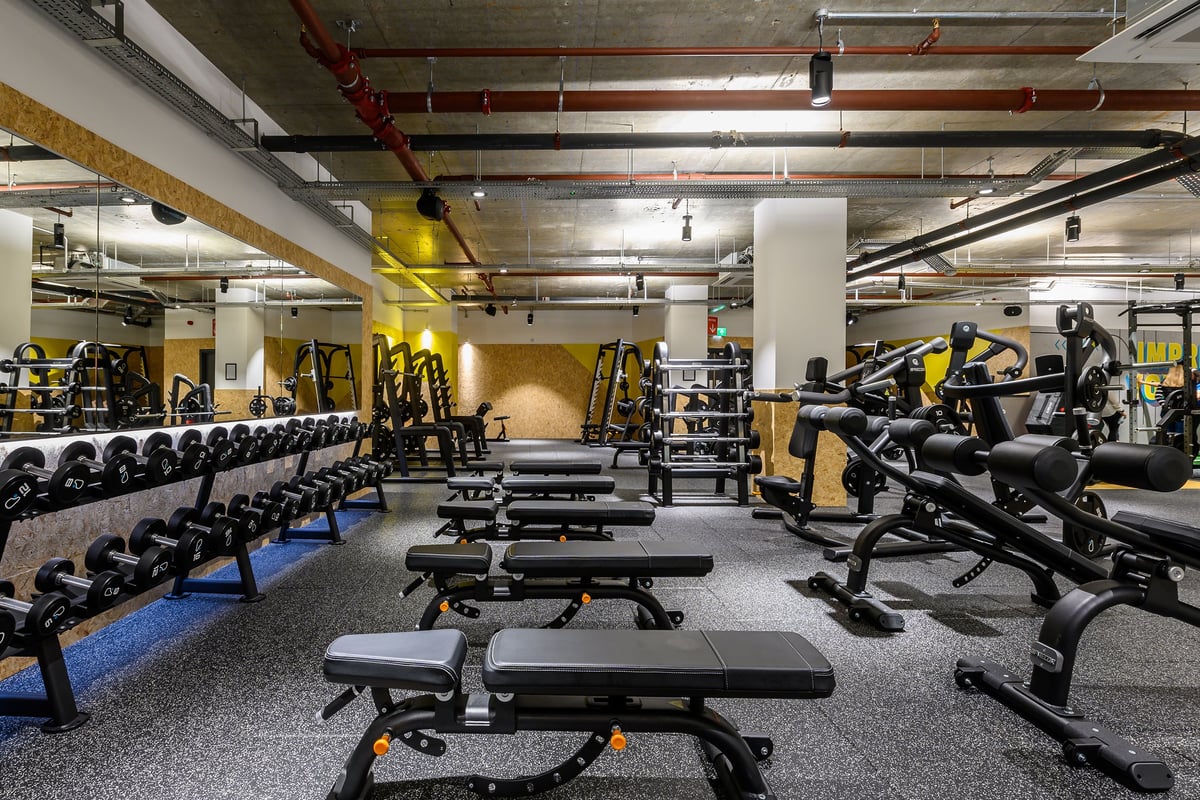 PureGym London Fulham: Rows of resistance machines, weight benches, dumbbells, and rubberized gym flooring.
