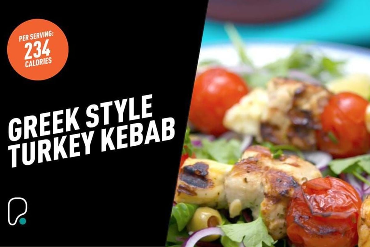 Grilled turkey kebab with cherry tomatoes and herbs on a white plate