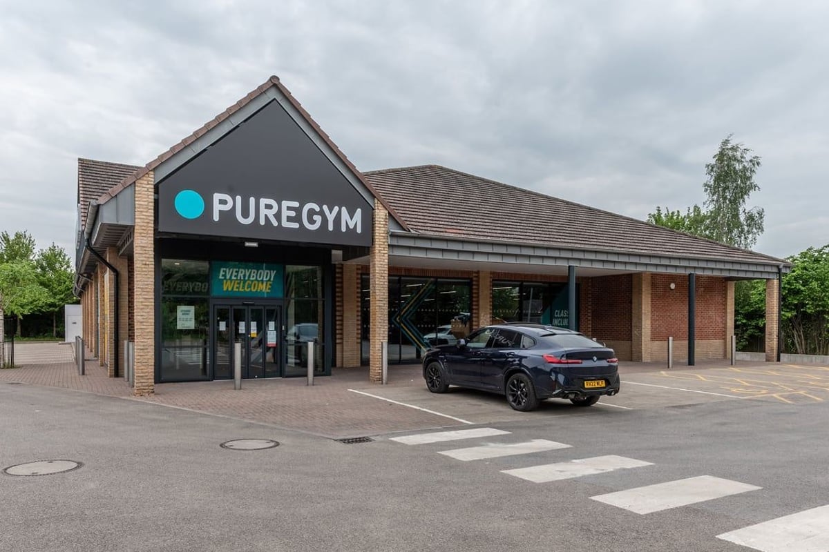 PureGym Knaesborough: Pure Gym building exterior with parking spaces and a car parked outside.
