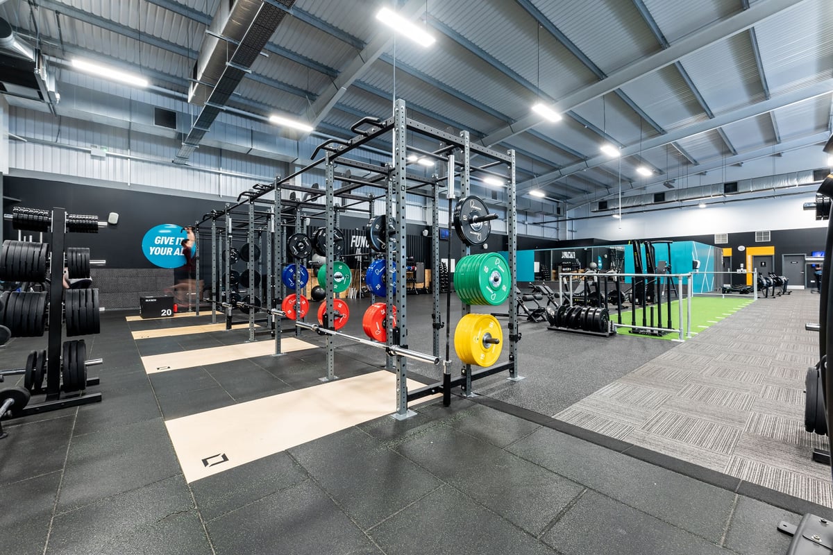 PureGym Widnes: Rig frames, weight plates in colourful discs, rubberised floor, mirrored walls.