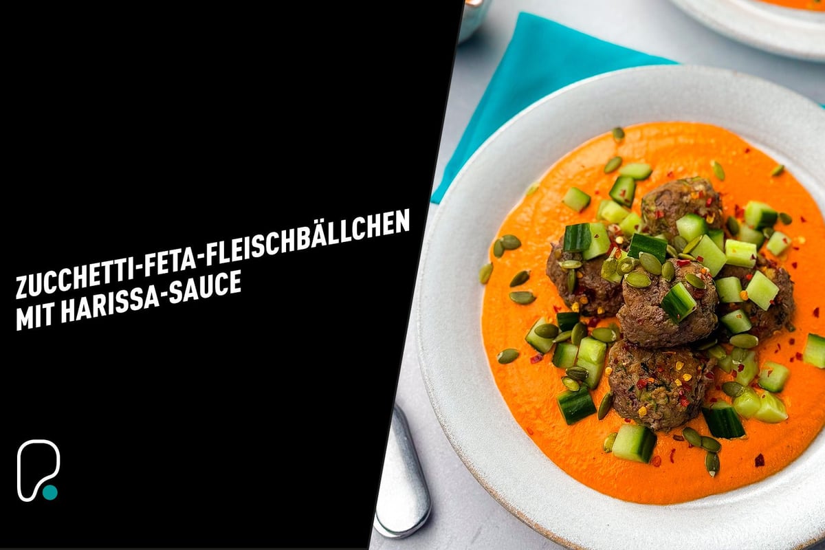 Meatballs with diced cucumber and pumpkin seeds on orange harissa sauce on a plate