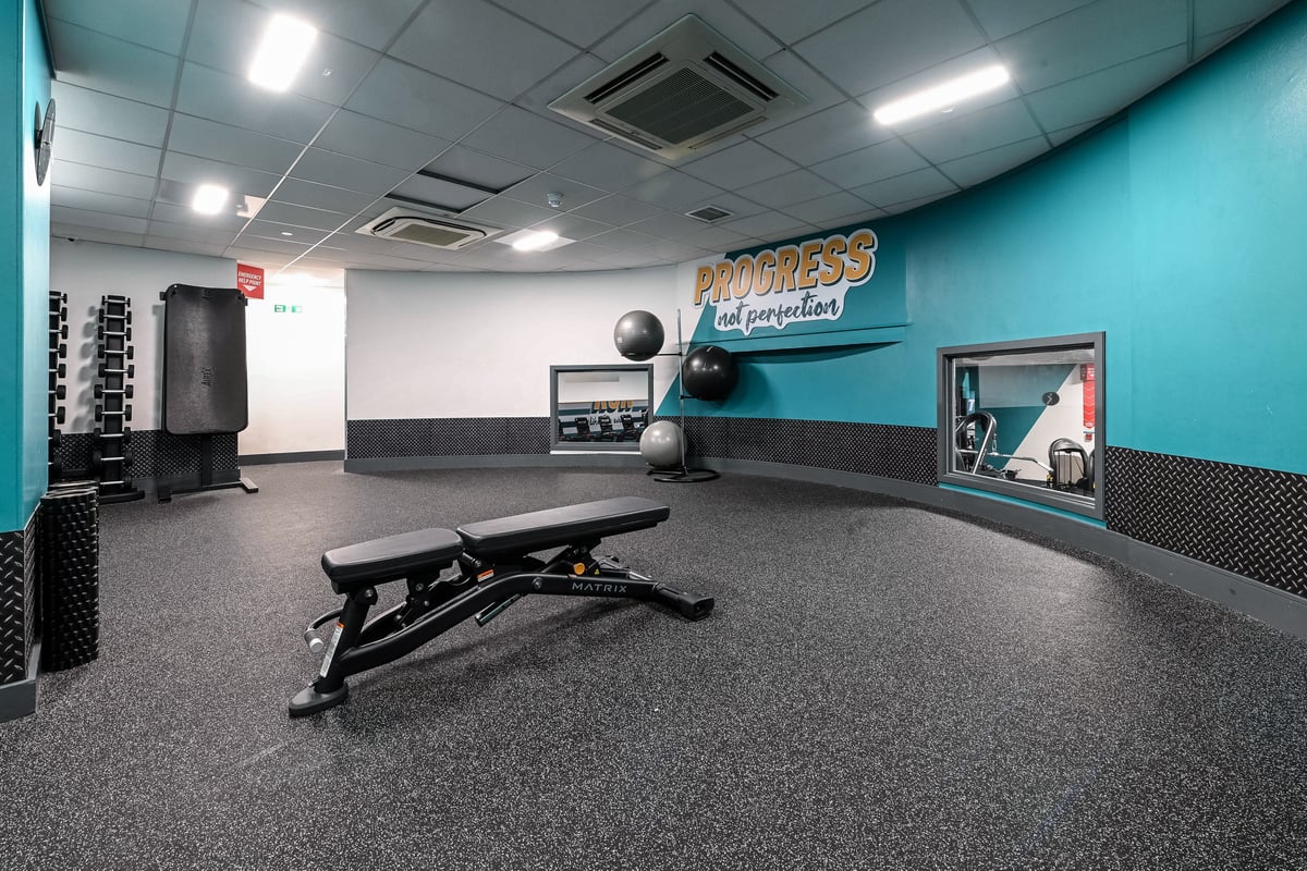 PureGym London Piccadilly: Bench, medicine balls, resistance bands, rubberized floor tiles, and mirrored wall.