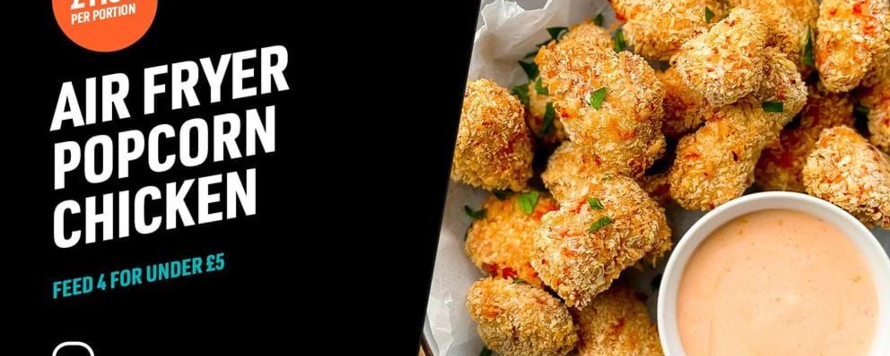 Breaded popcorn chicken pieces with dipping sauce on a plate with herbs