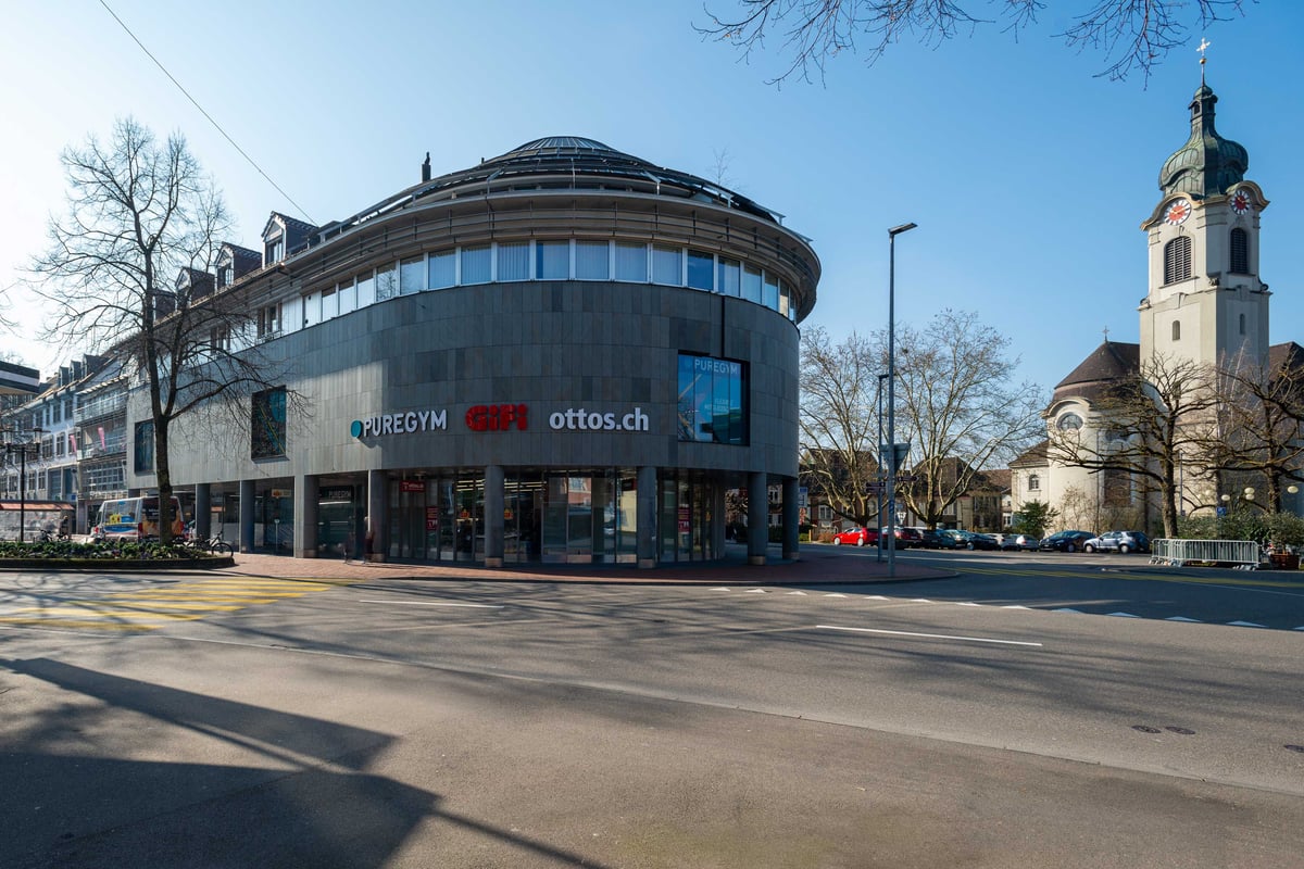 Vue extérieure de la gym PureGym Brugg dans un bâtiment arrondi en centre-ville