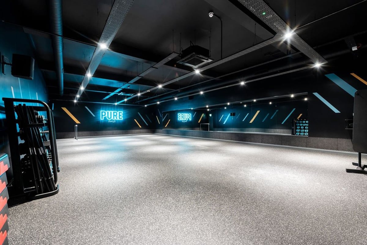PureGym Edinburgh Craigleith Retail Park: Futuristic studio with spotlights, screens, rubberized flooring.