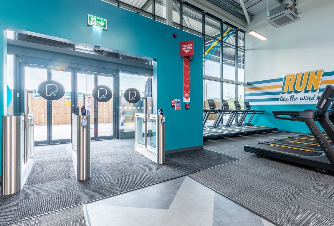 PureGym Nottingham Colwick: Treadmills, turnstiles, and "RUN like the wind" wall signage in a gym facility.