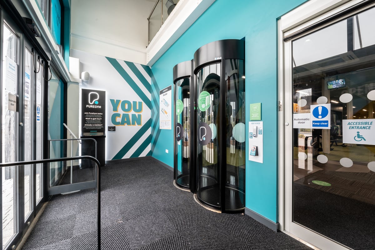 PureGym Plymouth Marsh Mills: Entry pods, turquoise walls, carpeted floor.