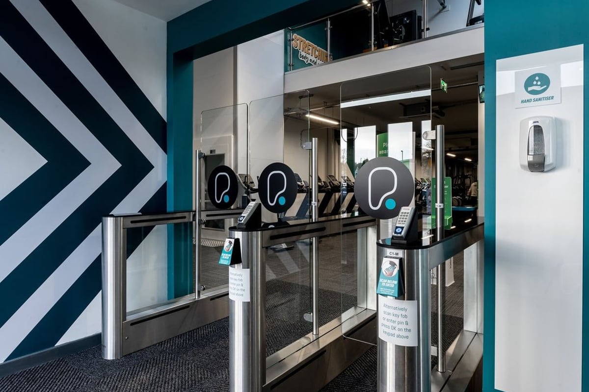 PureGym Inverness Inshes Retail Park: Rows of turnstiles and self-service kiosks at a gym entrance.