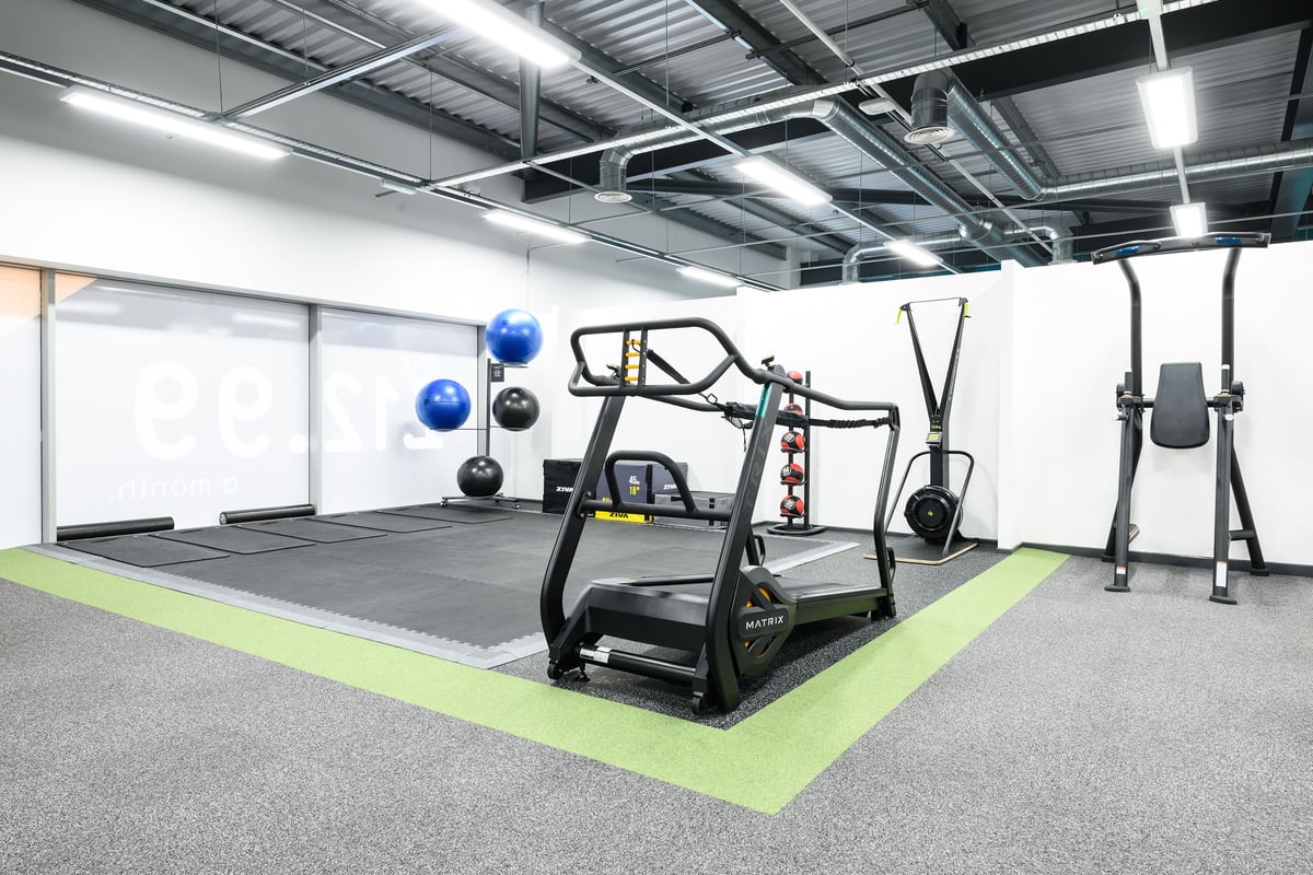 PureGym Newry: Sled push track, battle ropes, plyo boxes, heavy bag station, squat rig in industrial-style gym.