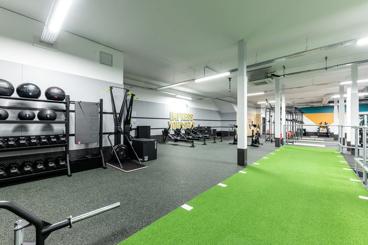 PureGym Solihull Sears Retail Park: Weight racks, medicine balls, squat racks, turf area, rubberized floor, gym equipment.