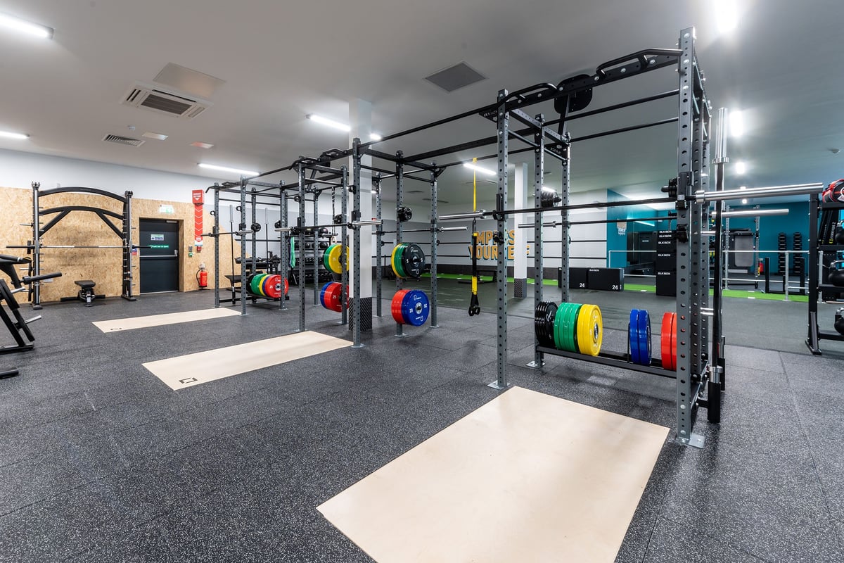 PureGym Knaesborough: Weightlifting rig, bumper plates, squat racks, rubberised flooring in a functional training space.