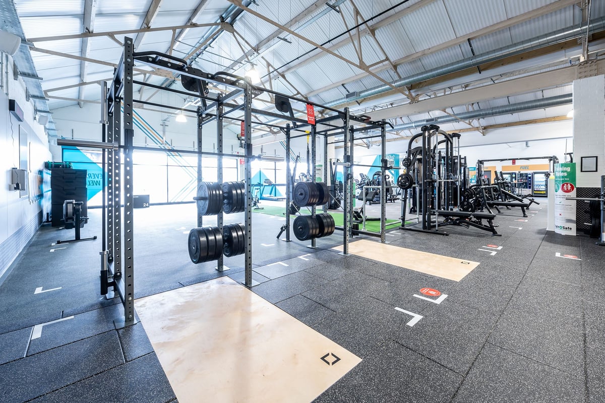 PureGym Puregym Crayford: Rig frames, weight racks, rubberized floors, and gym equipment in an indoor fitness facility.