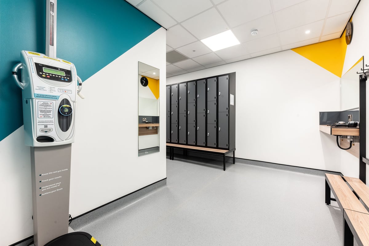 PureGym Merthyr Tydfil: Locker room with payment kiosk, lockers, and changing area.