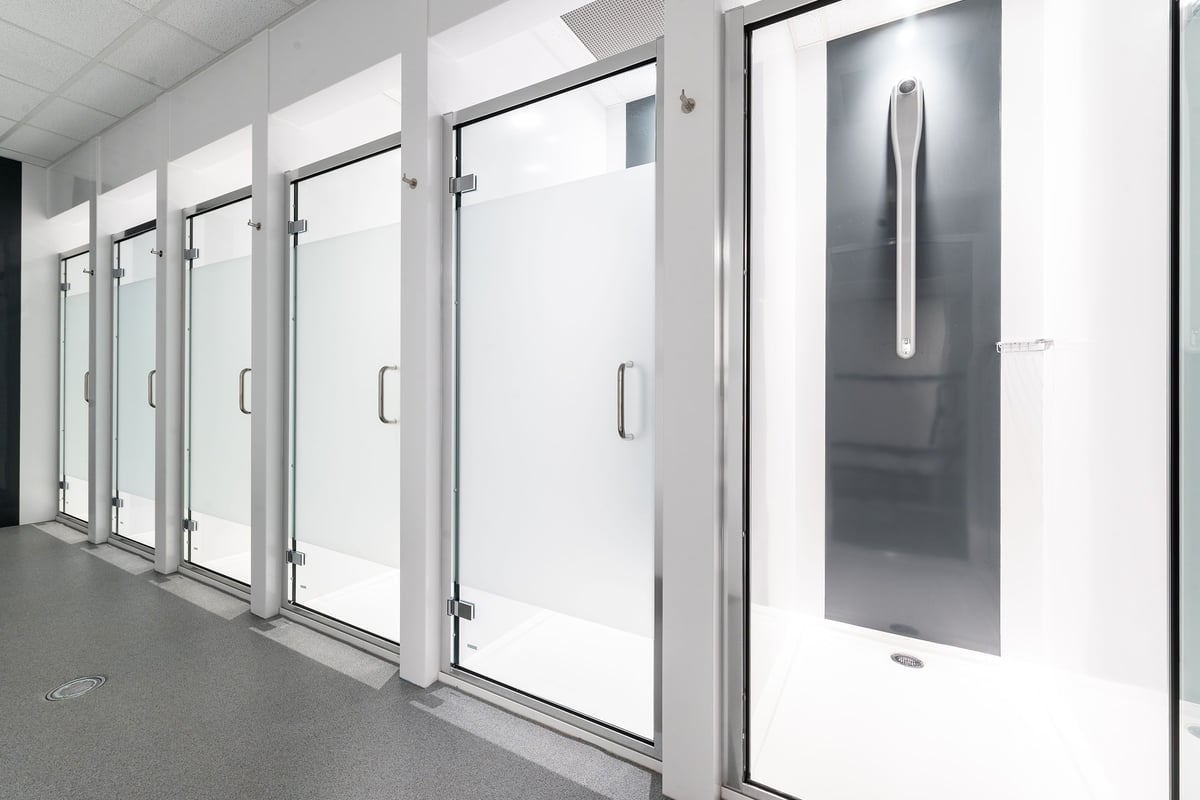 PureGym London Holloway Road: Shower stalls with frosted glass doors.
