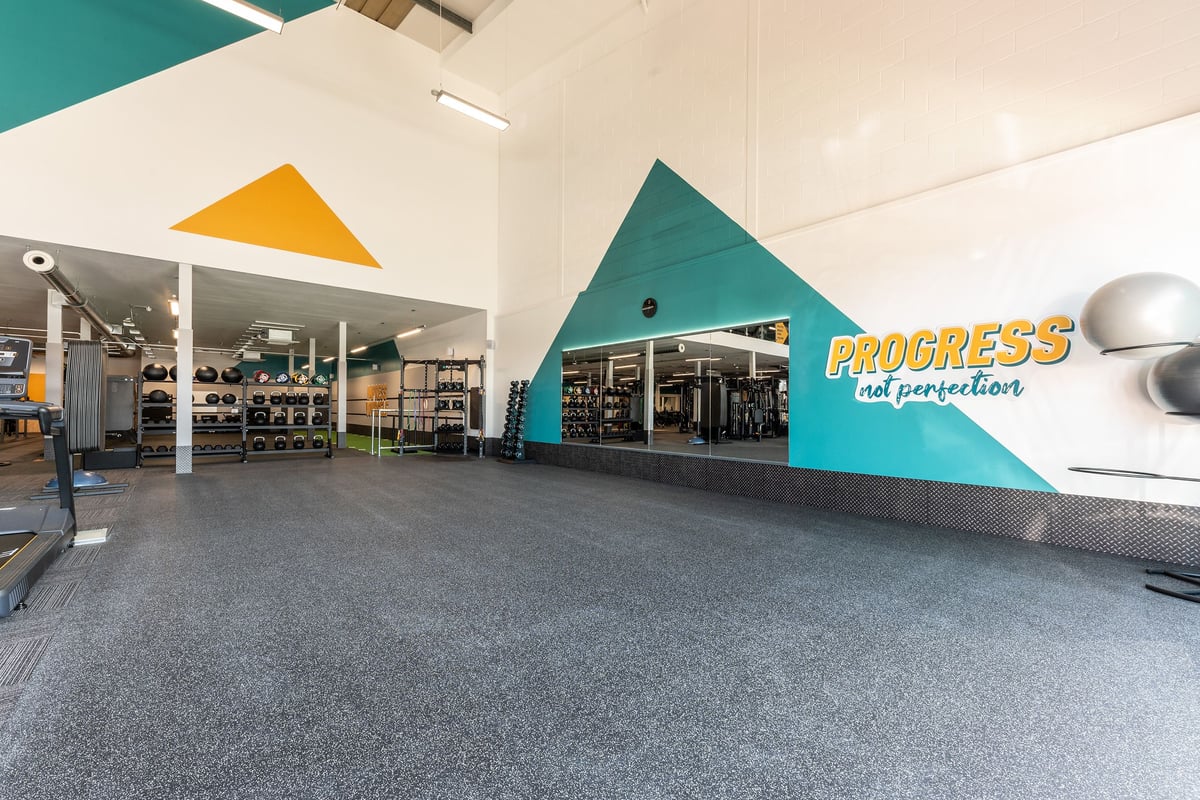PureGym Crewe Grand Junction Retail Park: Gym retail area with equipment displays, signage reading 'Progress in perfection'.