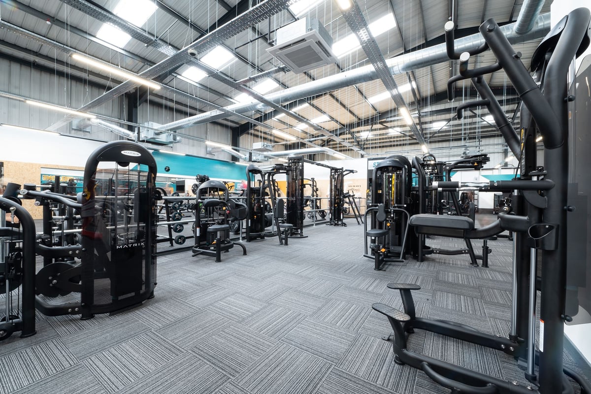 PureGym Dover: Large gym space with weightlifting machines, benches, free weights, and rubberized flooring.