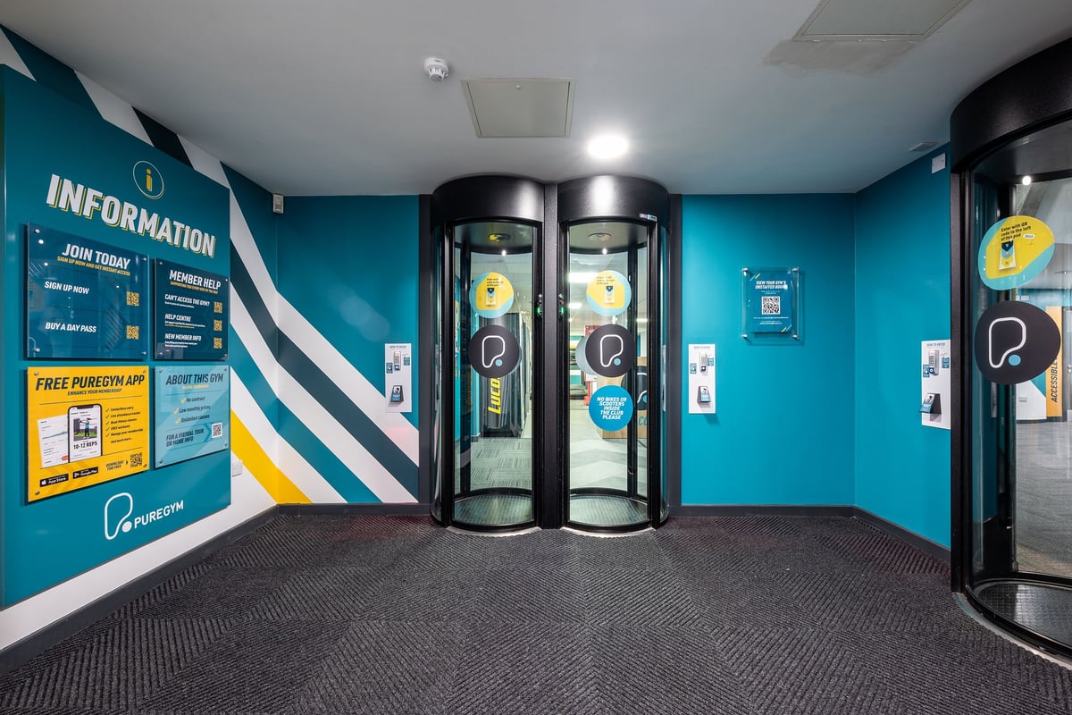 PureGym London Marylebone: Teal-coloured room with information stand, revolving cylindrical kiosks.