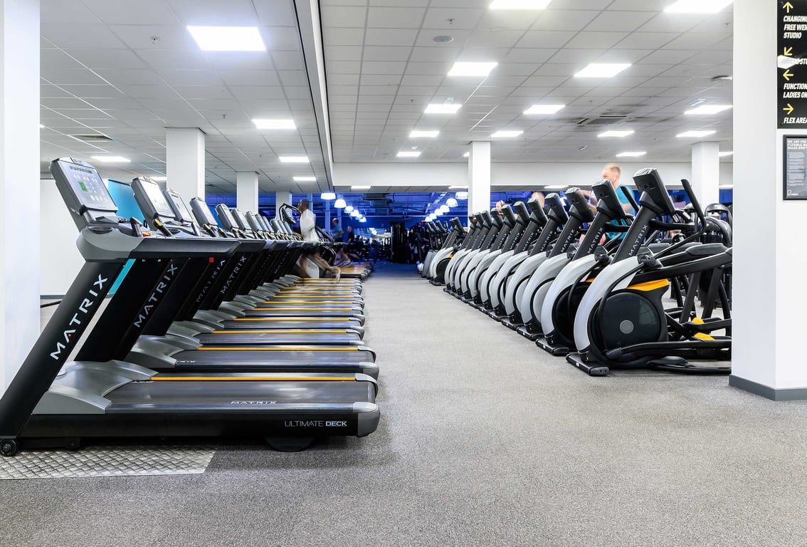 PureGym Glasgow Shawlads: Rows of treadmills and other aerobic machines in a modern gym facility.
