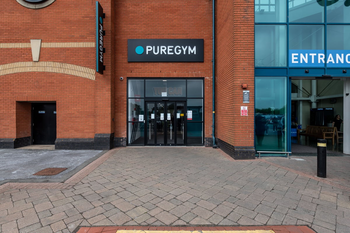 PureGym Peterborough Serpentine Green Shopping Centre: Pure Gym entrance exterior with brick facade, glass doors and signage.