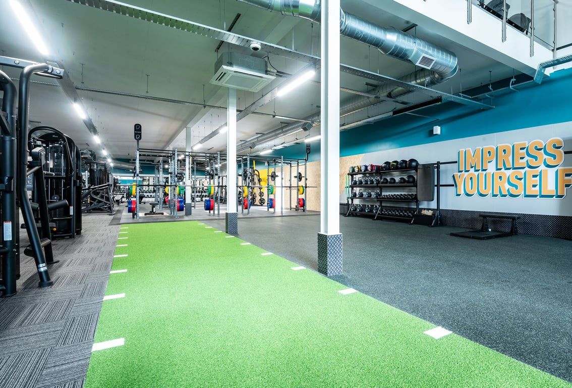 PureGym Glasgow Rutherglen: Weight racks, cardio machines, turf area and free weights.