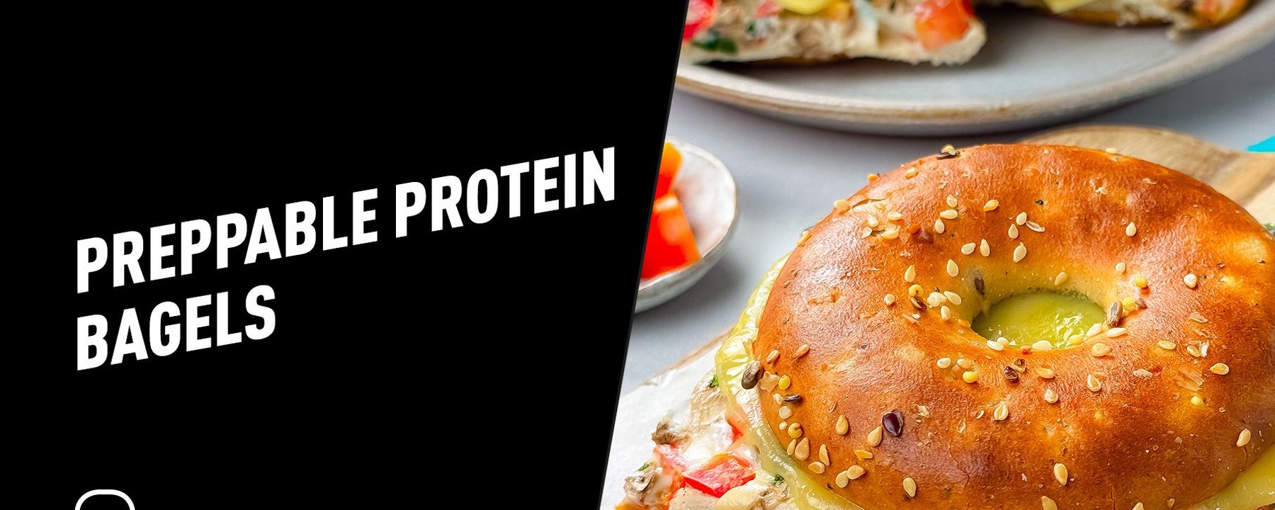 Sesame seed bagel sandwich with melted cheese and vegetable cream filling on a wooden board