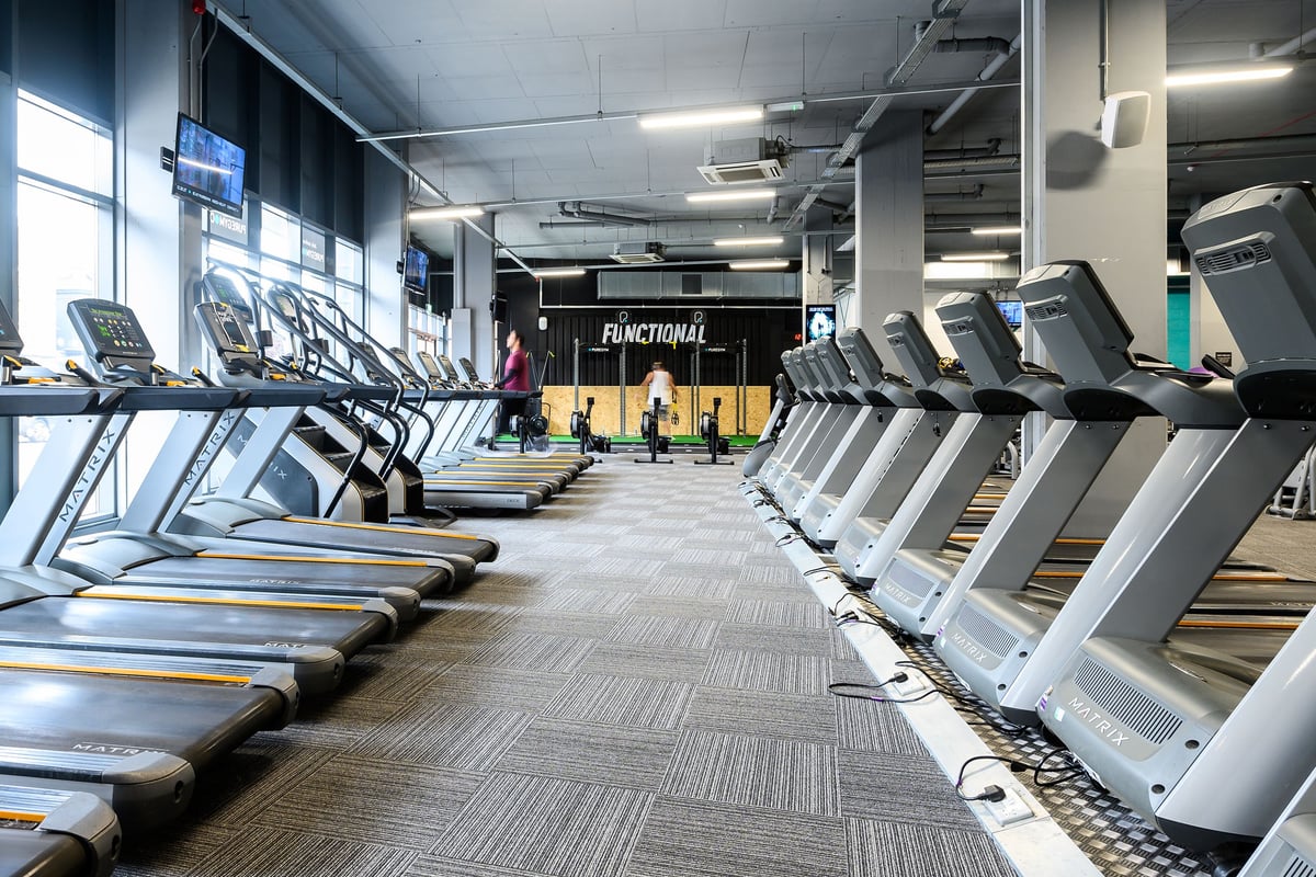 PureGym London Acton: Rows of treadmills, functional training area with signage, in a modern gym interior.