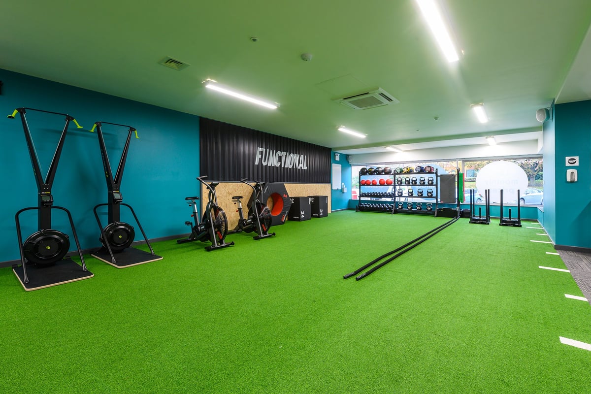 PureGym Didcot: Functional training area with green turf, cable machines, punching bags, and exercise equipment.