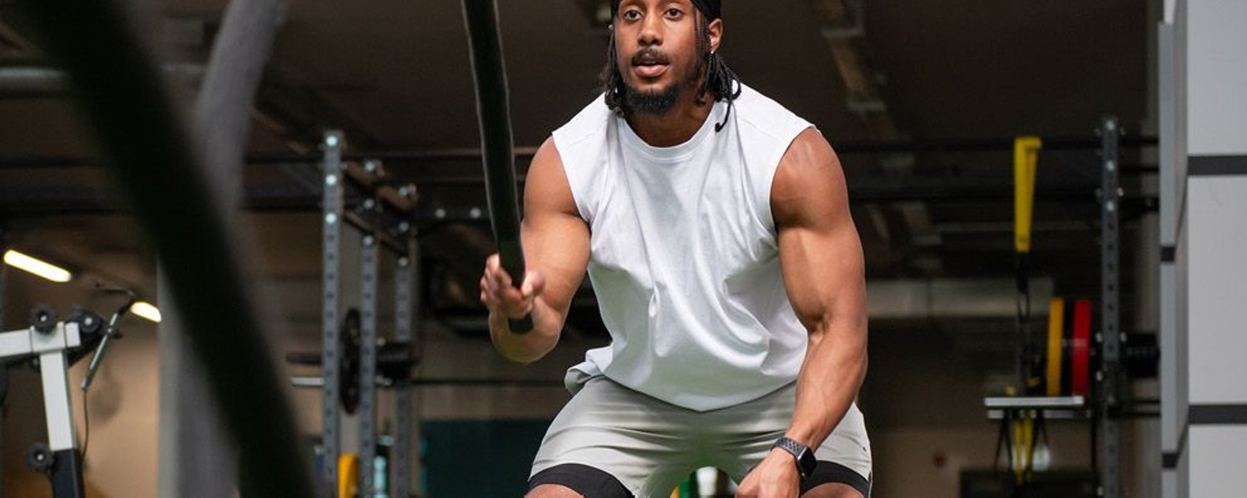 Man using battle ropes in gym setting