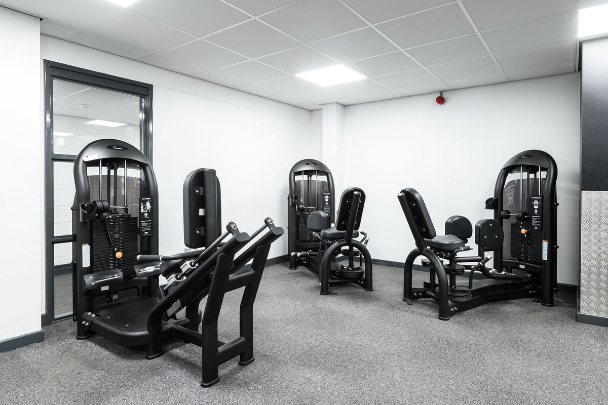 PureGym Burnham: Weight machines, resistance equipment, and mirrors in a fitness studio.