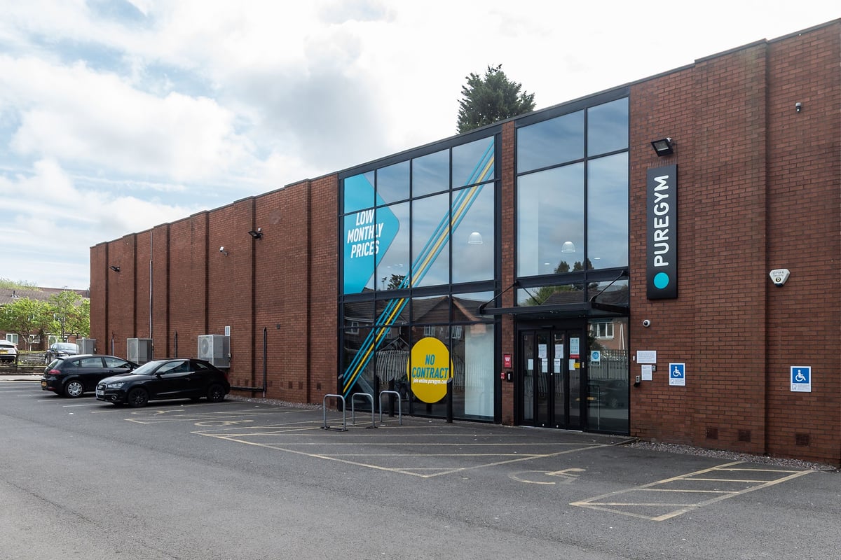 PureGym Sutton Coldfield: Brick building exterior with PureGym sign and entry and accessible parking spots shown.