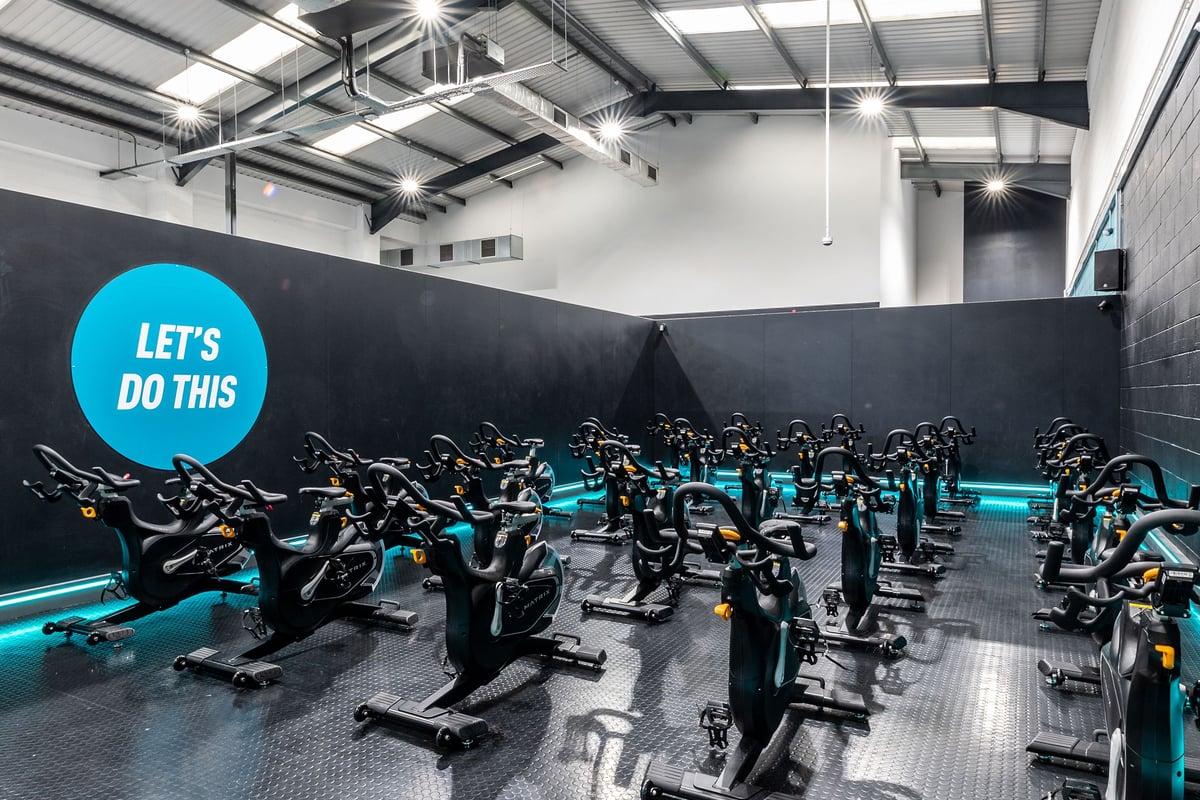 PureGym Leeds Hunslet: Rows of stationary bikes inside a modern cycling studio with bright lighting.