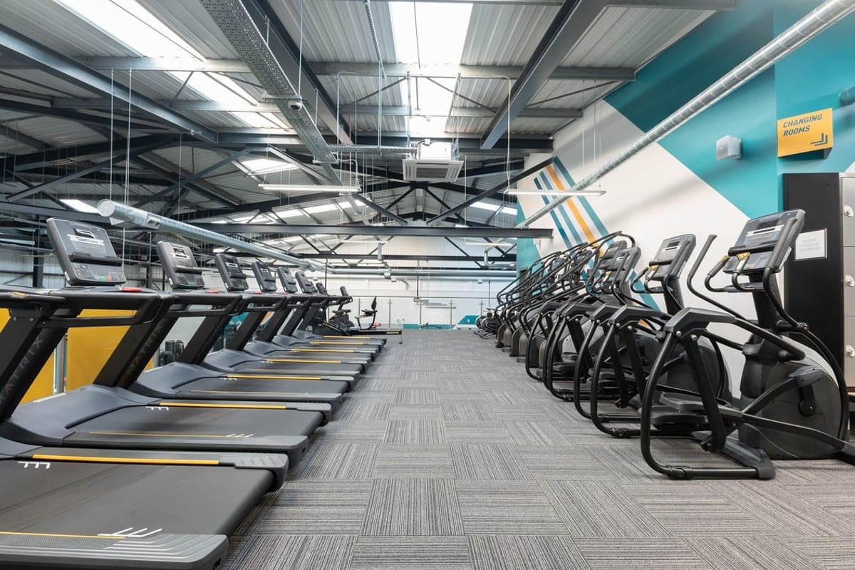PureGym Southport: Rows of treadmills and exercise bikes in a bright gym interior with mirrored walls.