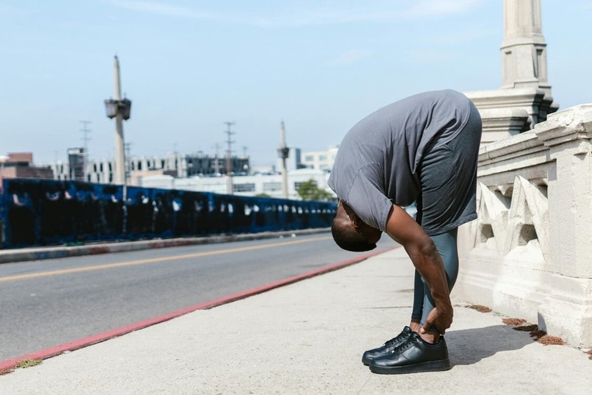 Man stretching on bridge
