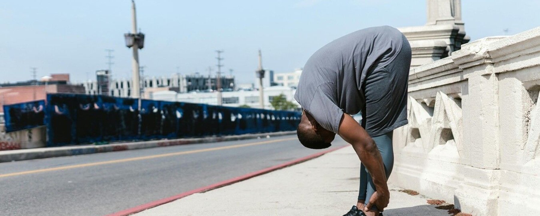 Man stretching on bridge