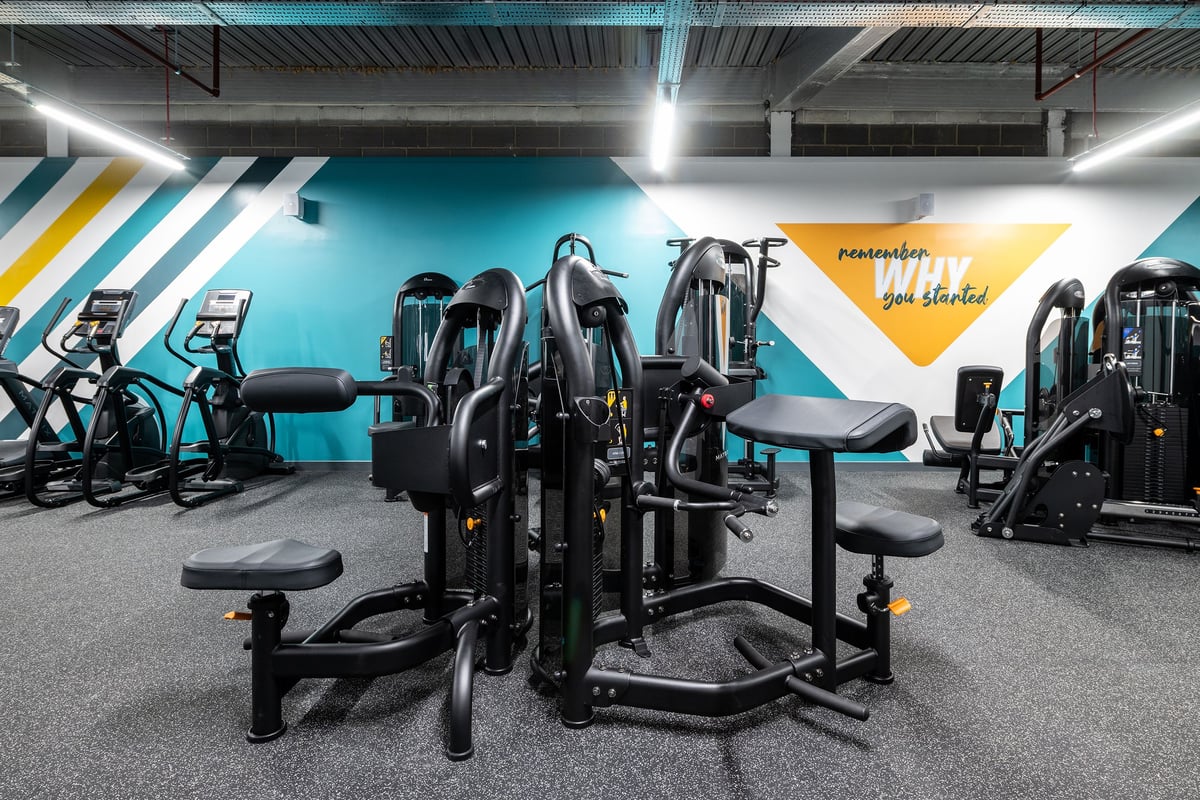 PureGym Erith : Weight machines, resistance equipment, on rubberized flooring in a gym.