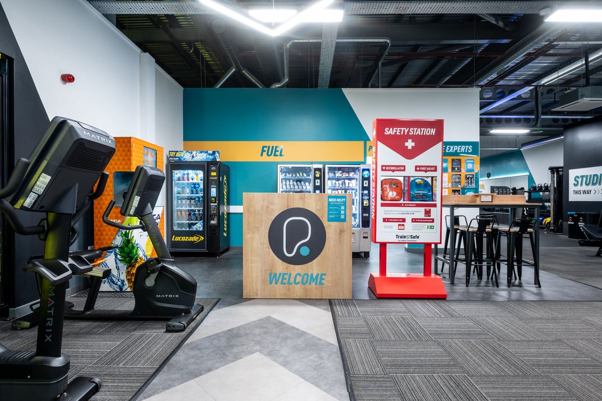 PureGym Peterborough Serpentine Green Shopping Centre: Welcome area with kiosk, safety station, and fitness equipment.