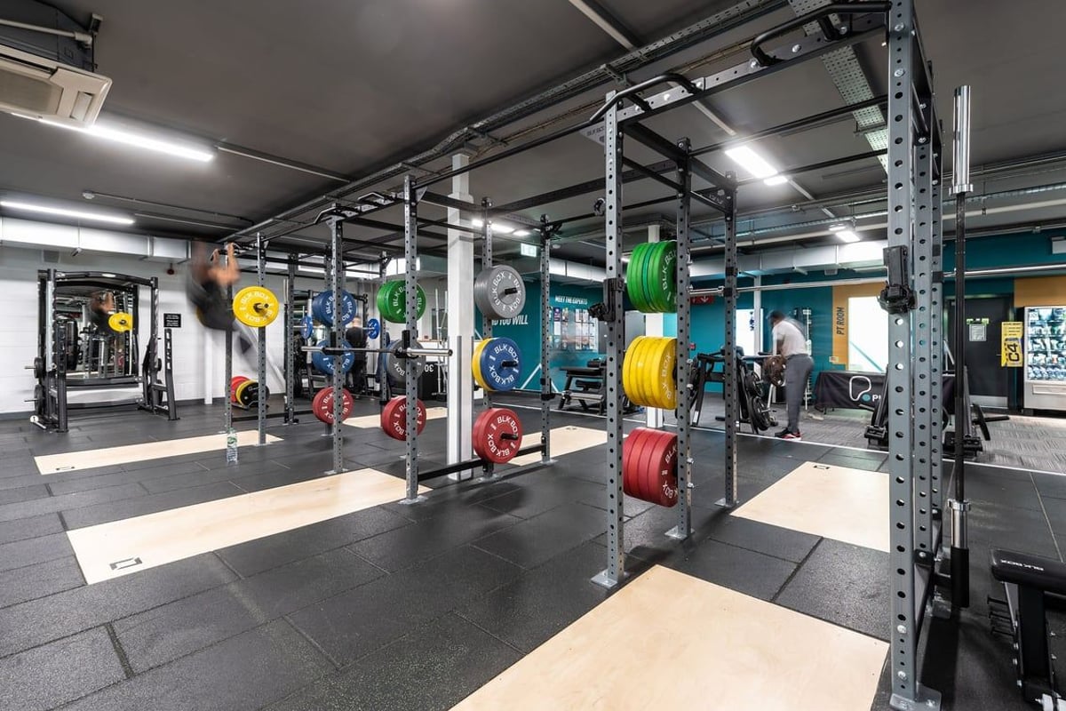 PureGym Oldham: Racks of weight plates in various colours, power racks, rubberized flooring.