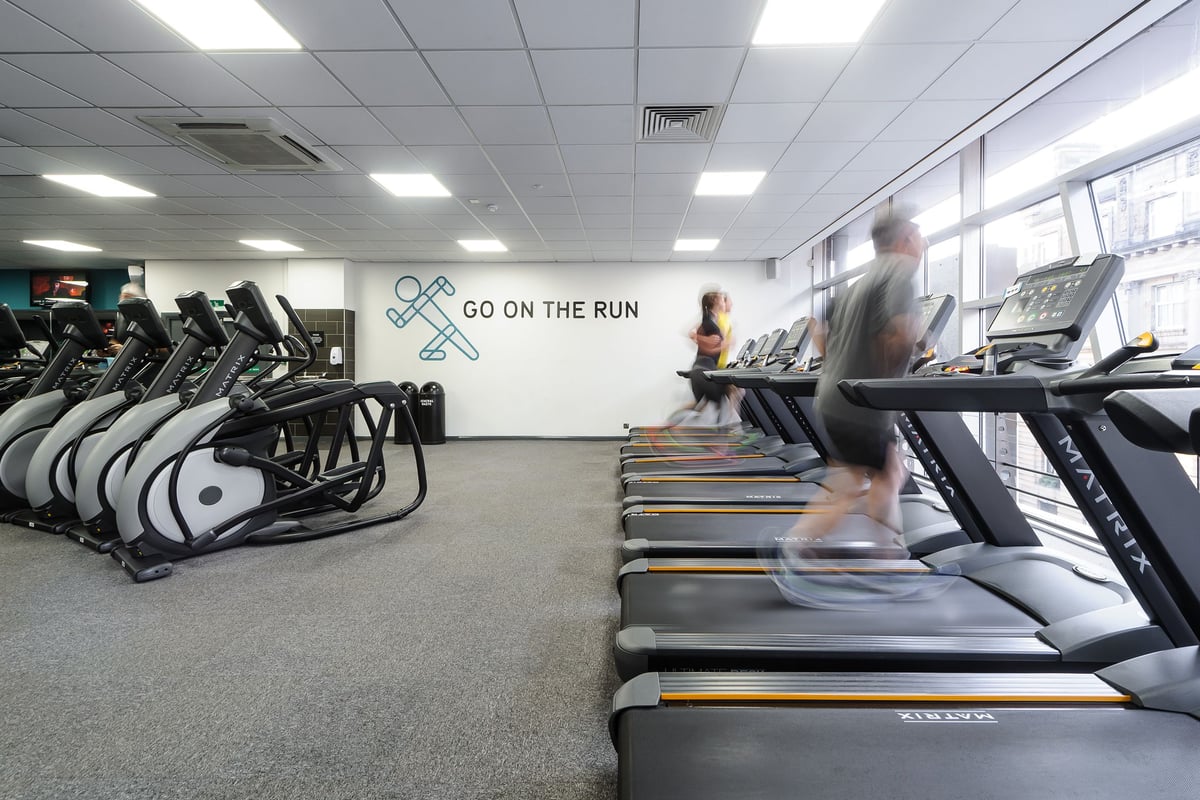 PureGym Glasgow Bath Street: Rows of treadmills and elliptical cross-trainers inside a well-lit fitness studio.