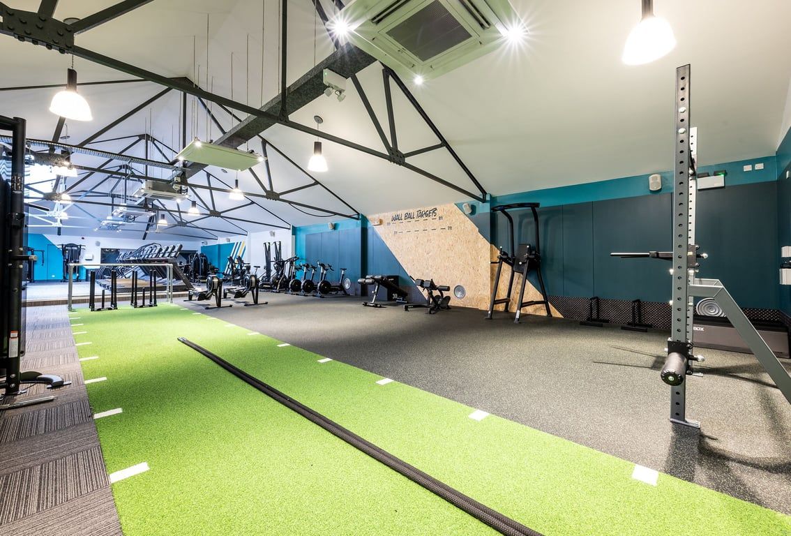 PureGym London Marylebone: Strength training area with squat racks, turf track, free weights, and exercise machines.