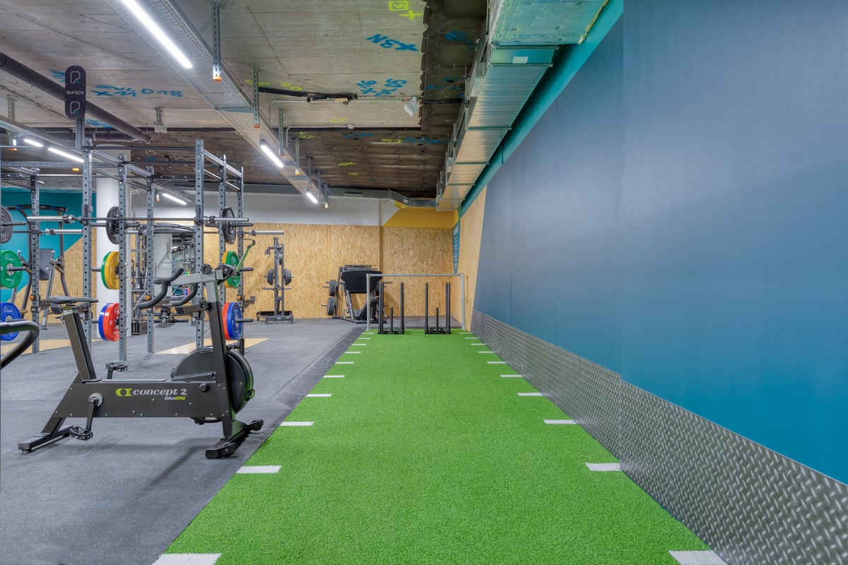 Zone de functional training dans le gym de Schaffhouse avec gazon artificiel vert et marquages blancs