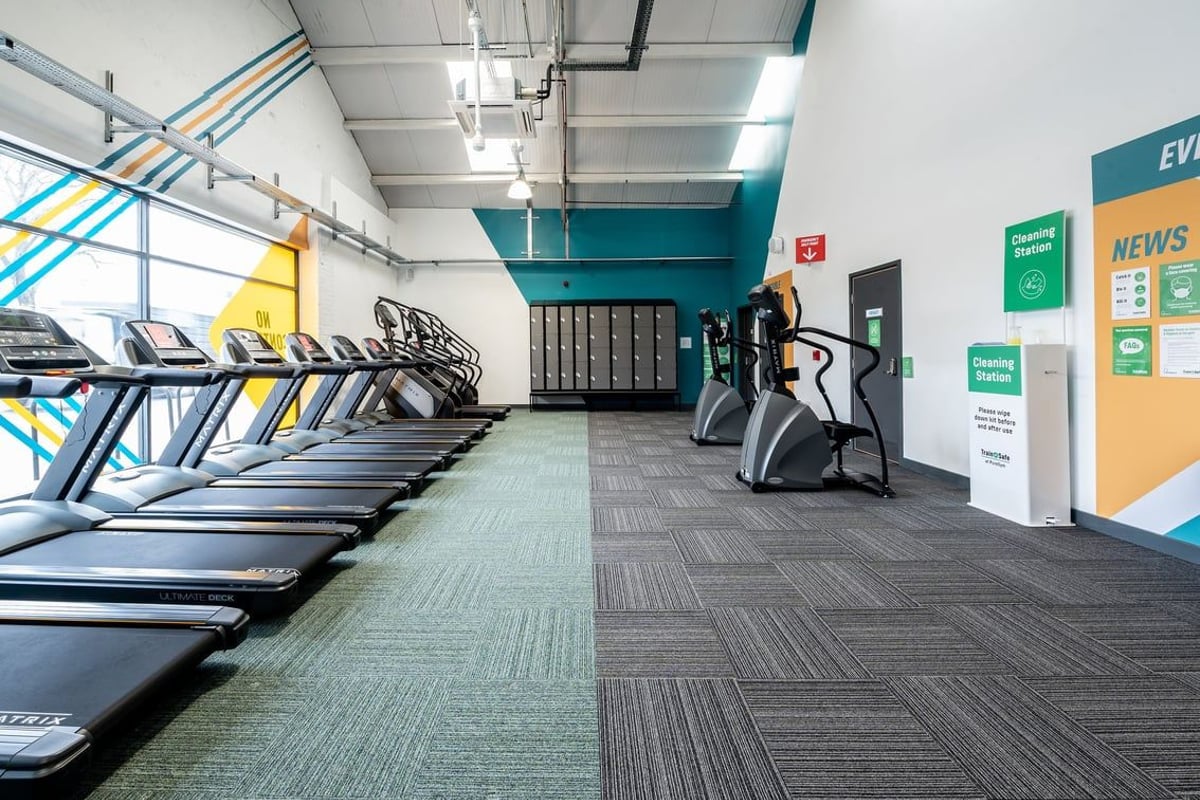 PureGym Puregym Crayford: Rows of treadmills, exercise bikes, weight machines, and signage in a gym setting.