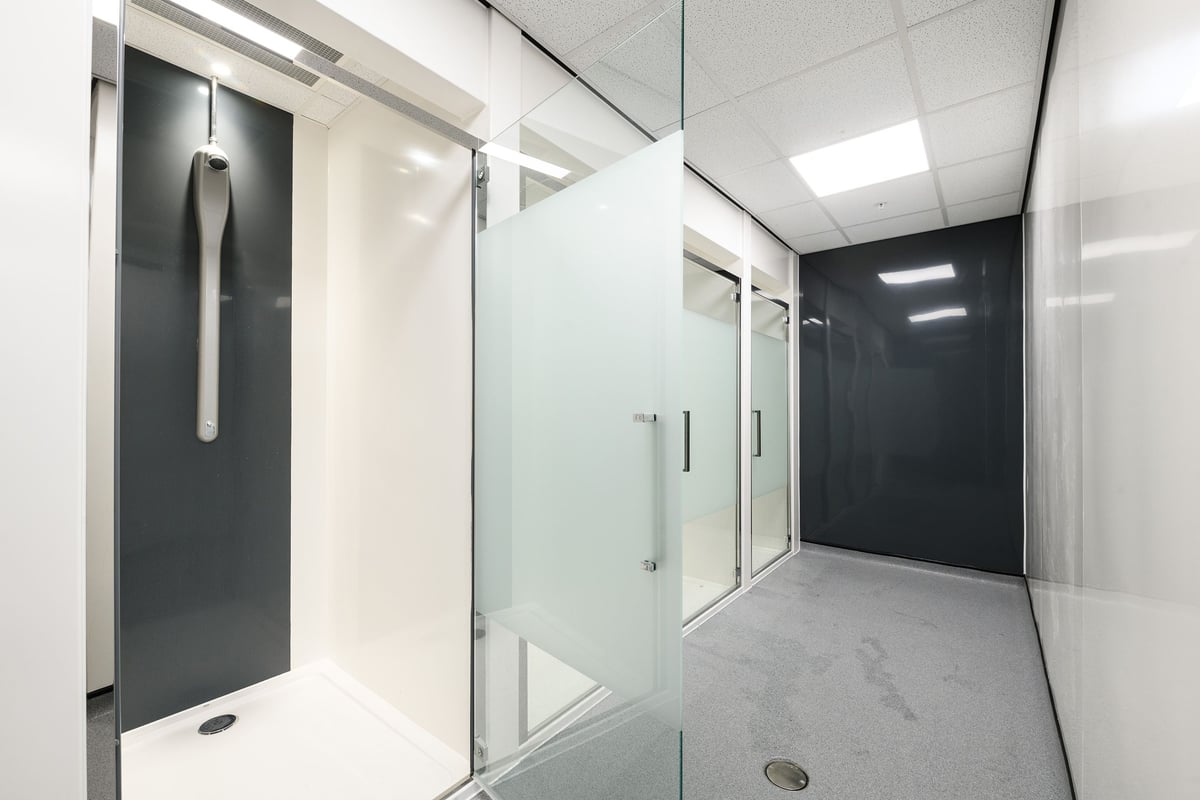 PureGym Cambridge Grafton Centre: Shower rooms with frosted glass doors and tiled floors.
