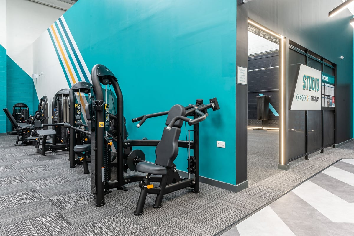 PureGym Chippenham: Resistance machines, free weights, benches in teal-coloured studio with rubberized flooring.