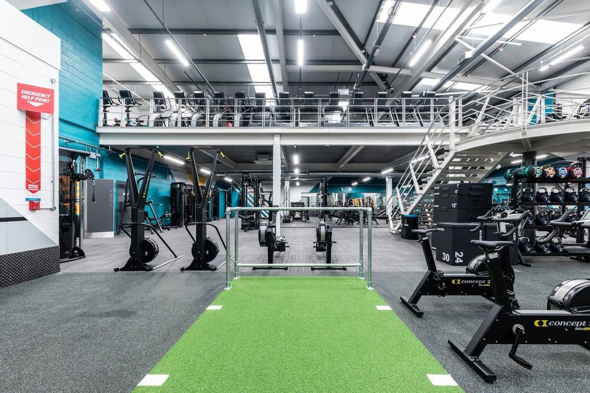 PureGym Sheffield Crystal Peaks: Rows of cable machines, squat racks, turf area, free weights, and ceiling-mounted rigs.