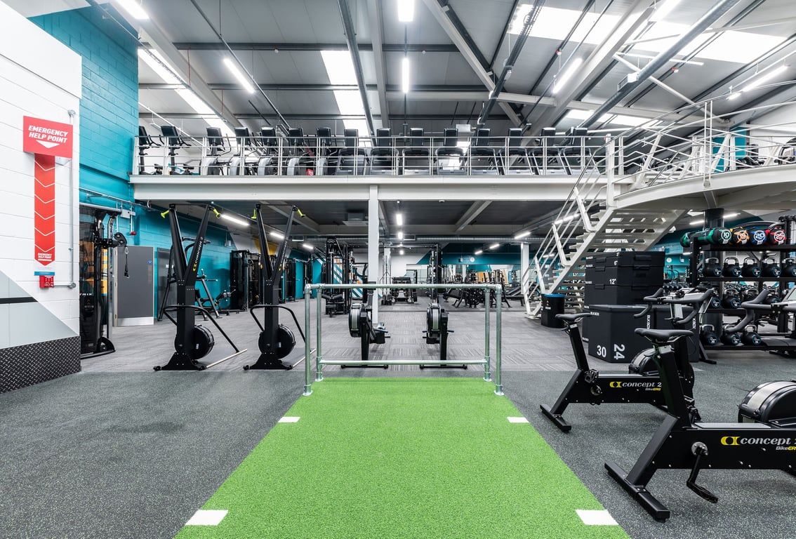 PureGym Sheffield Crystal Peaks: Rows of cable machines, squat racks, turf area, free weights, and ceiling-mounted rigs.