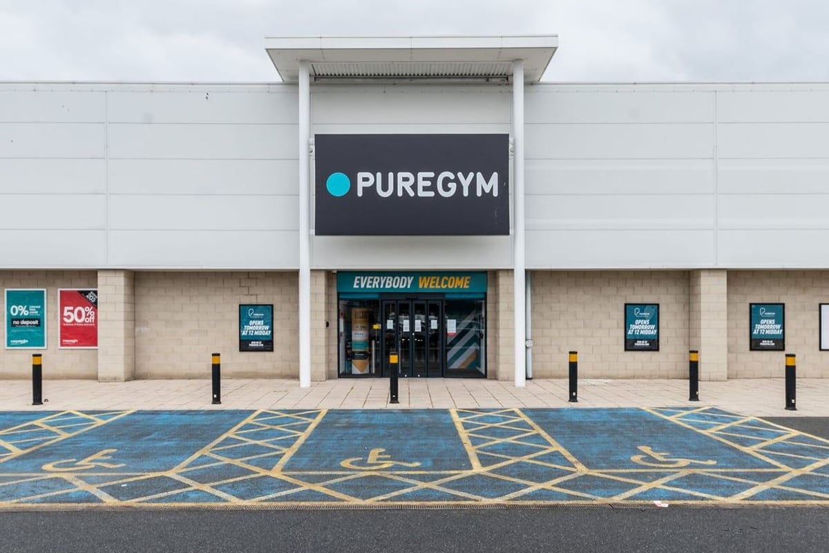 PureGym Blyth: The gym entrance with 'PUREGYM' signage, parking spaces, and promotional banners.