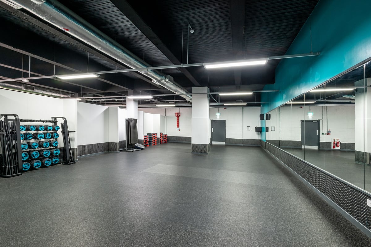 PureGym Manchester Market Street: Rubberized flooring, weight racks, plyometric boxes, mirrored walls, industrial ceiling.