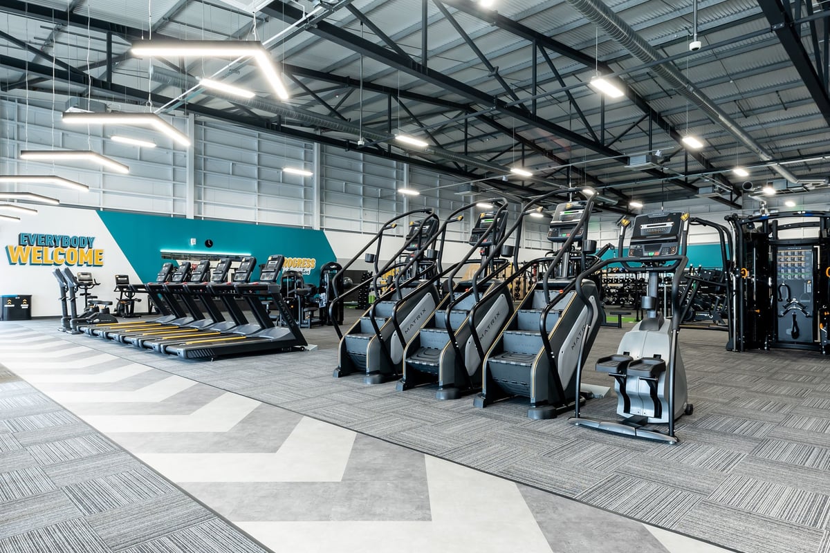 PureGym Ipswich Ravenswood: Rows of treadmills, ellipticals, and other cardio fitness equipment in a gym facility.