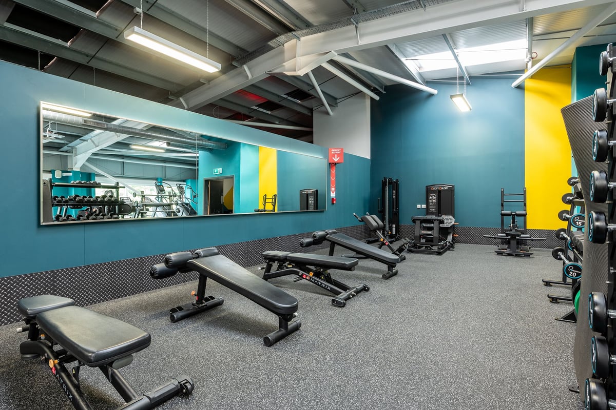 PureGym Wirral Bidston Moss: Weight benches, resistance machines, mirrors, and free weights on rubberized flooring.